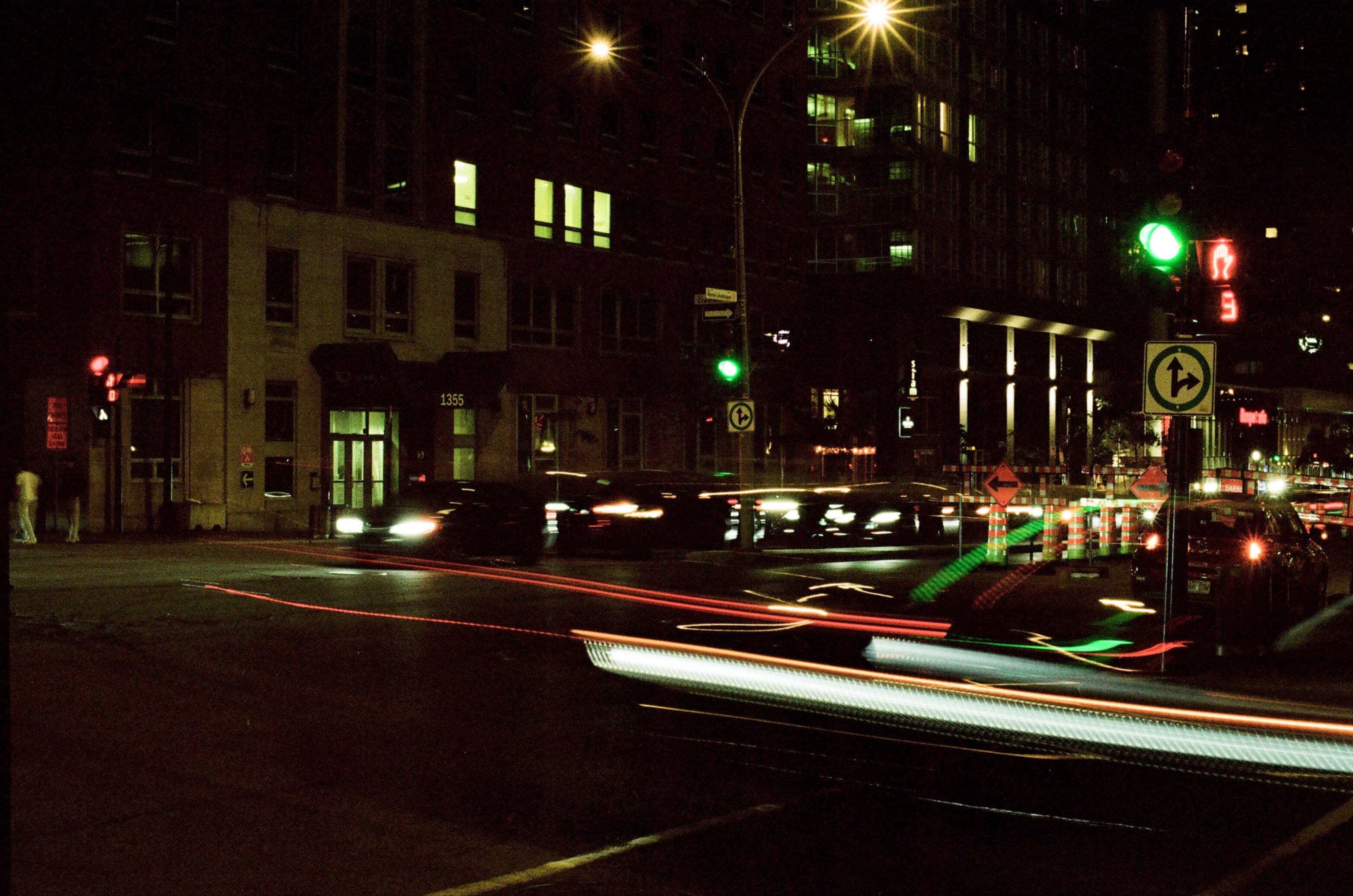 A city street at night with streaks of light from passing cars over a long exposure