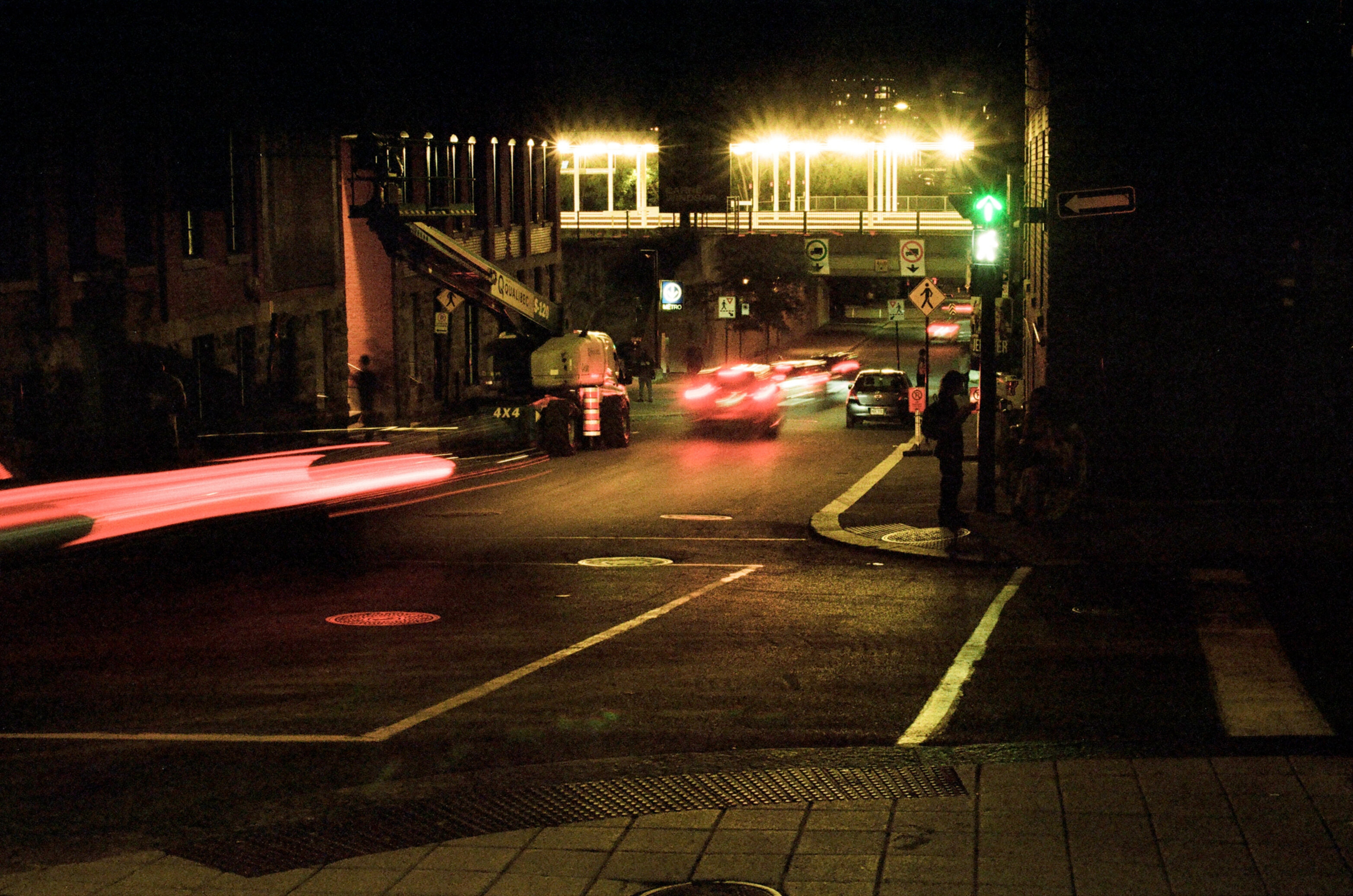 A city street at night with streaks of light from passing cars over a long exposure