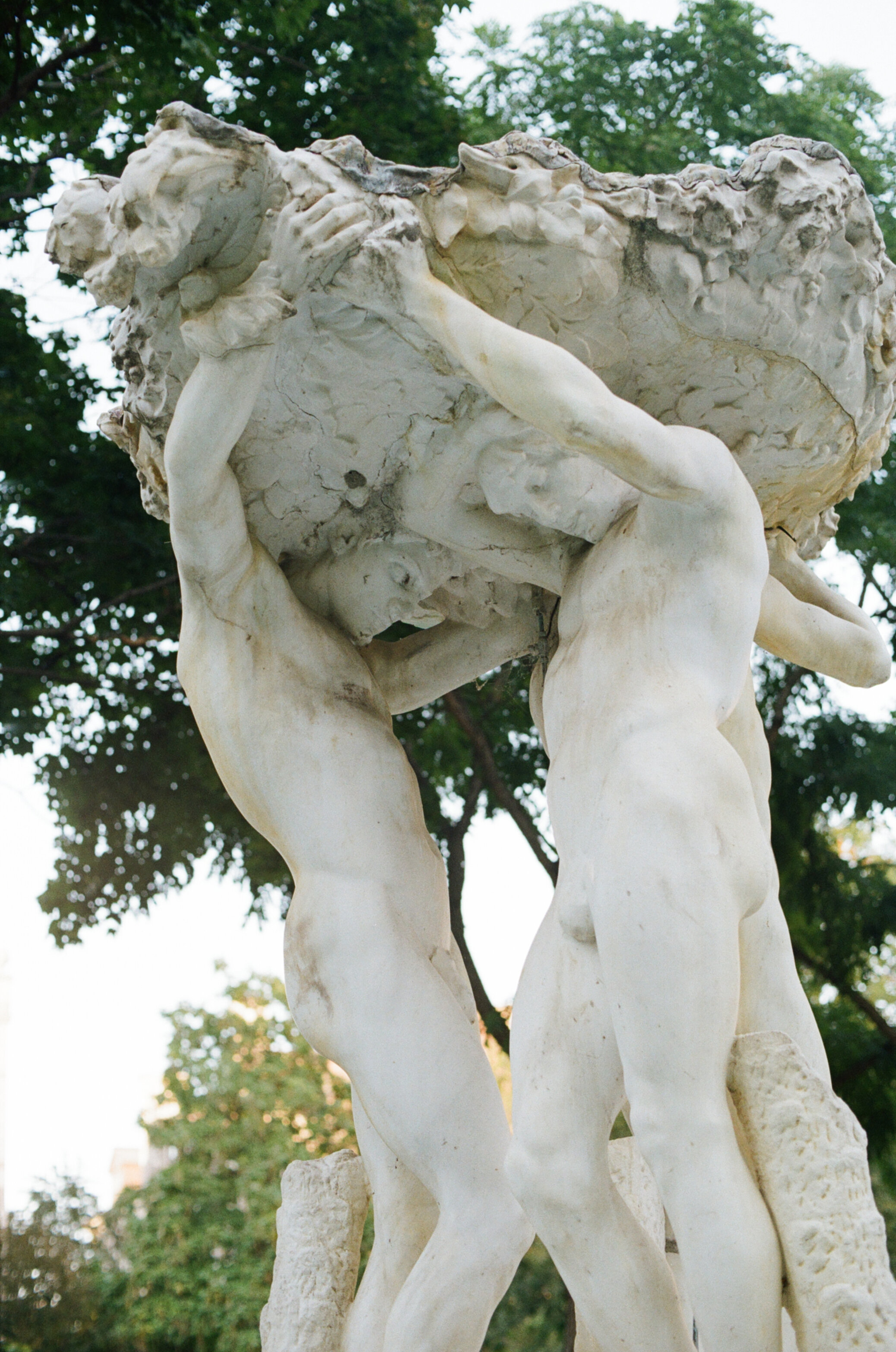 Marble fountain in the shape of a platform held up by three nude men