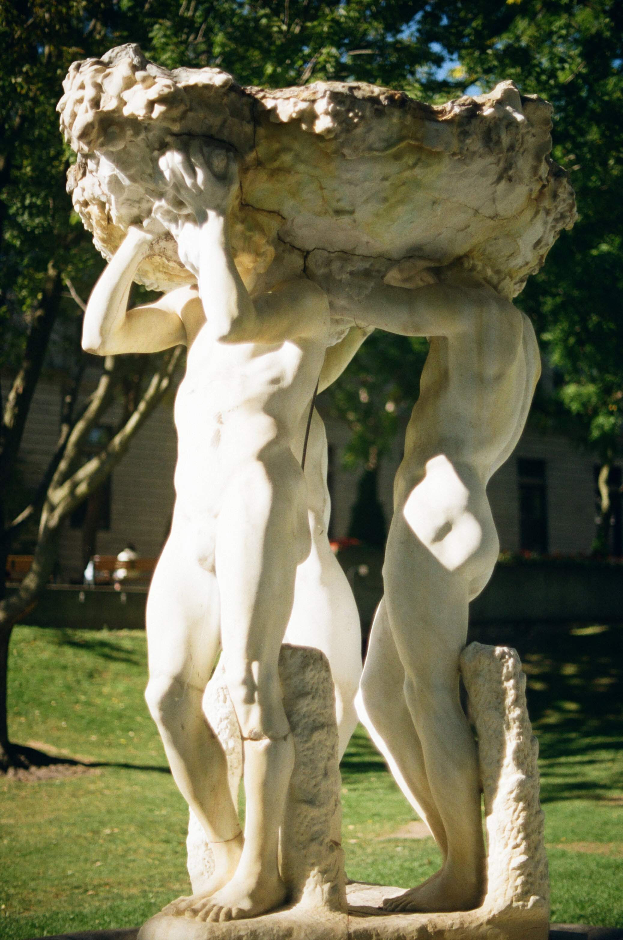 Marble fountain in the shape of a platform held up by three nude men