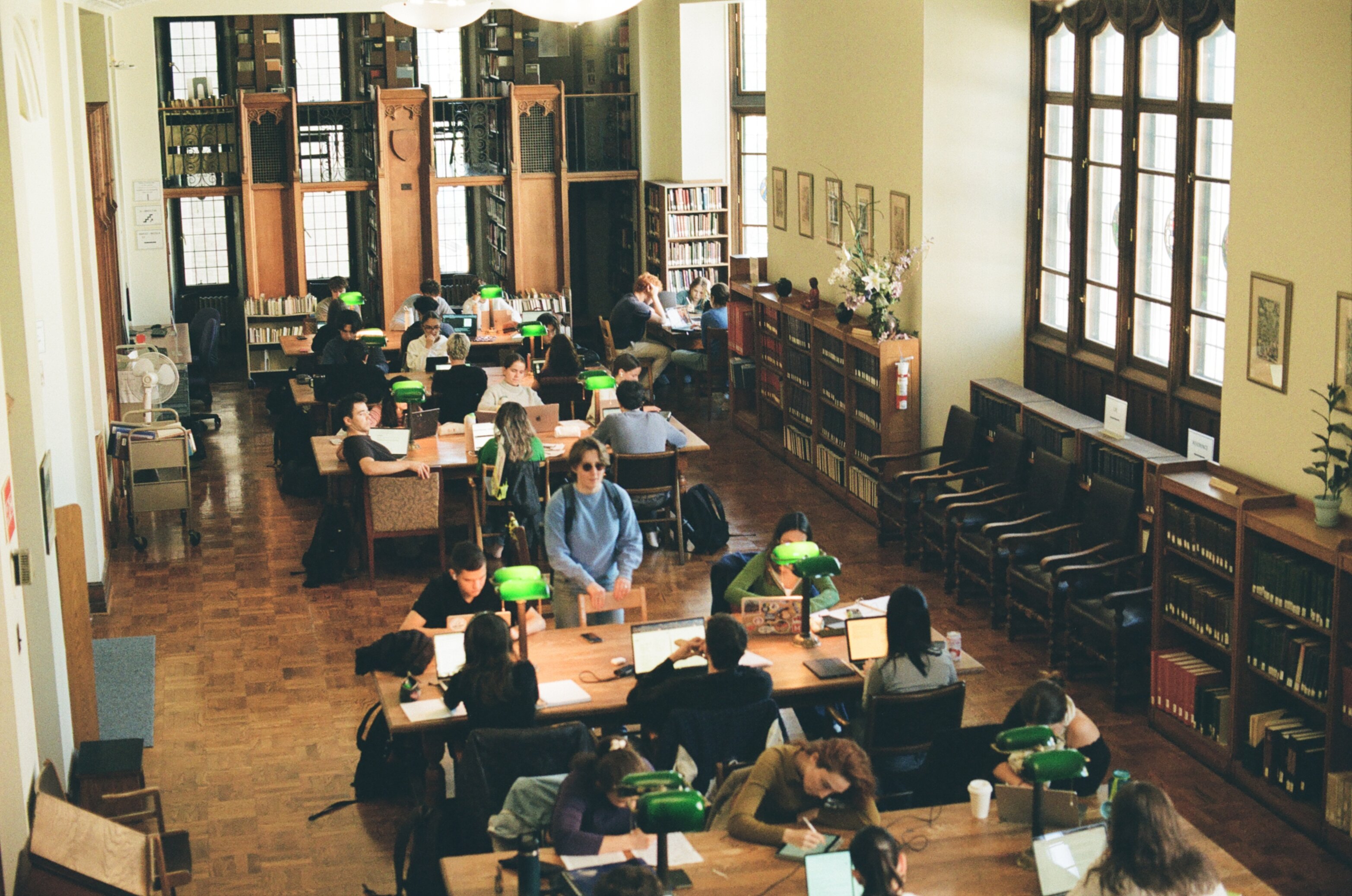 Wood-paneled library packed with students all doing homework