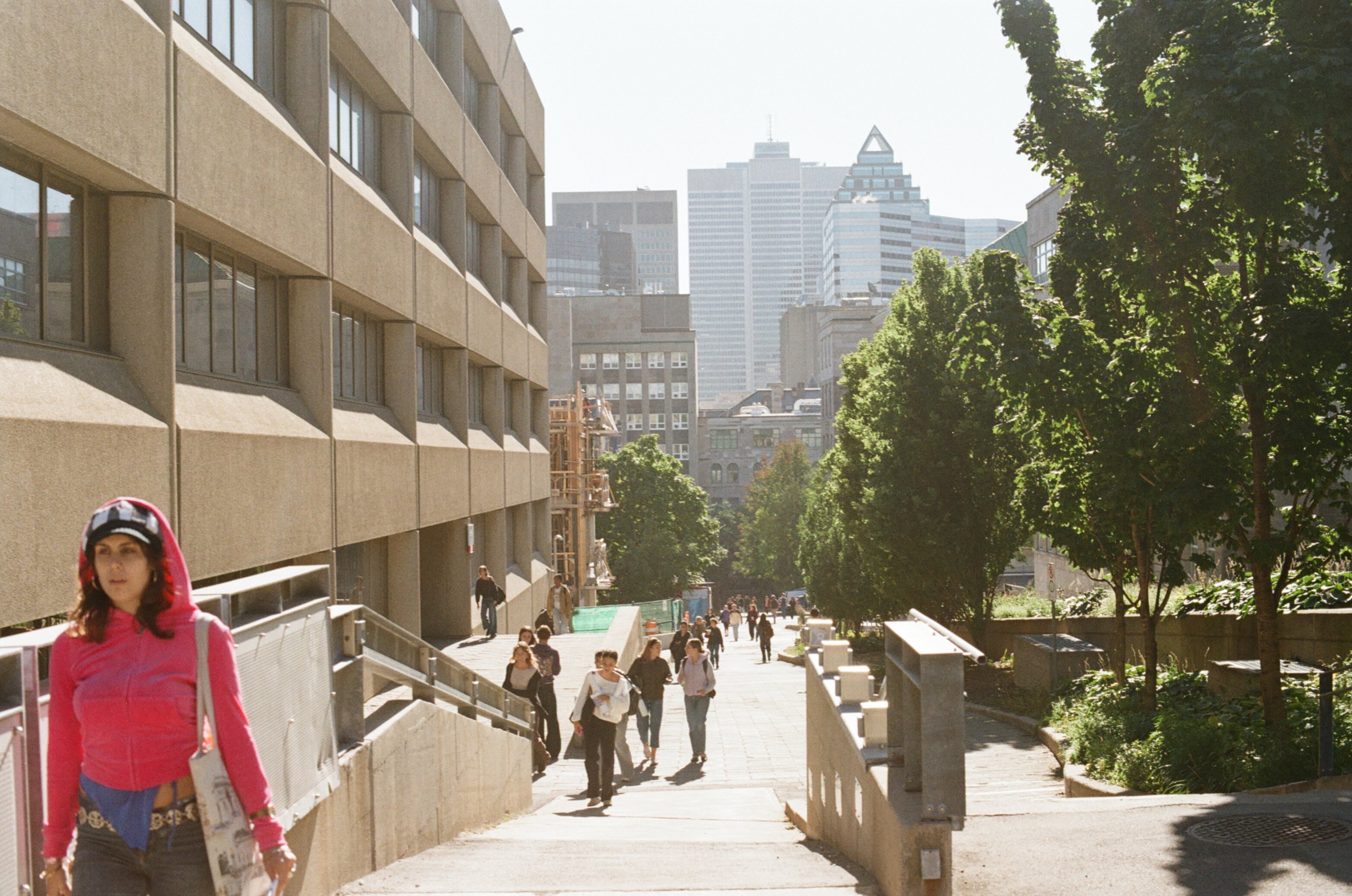 Students walk up a steep street between university buildings in the morning